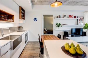 Modern kitchen and dining area with wooden accents and sleek design.