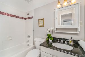 Modern bathroom with black countertop and white fixtures.