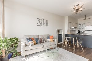Bright modern living room with sofa and open kitchen.
