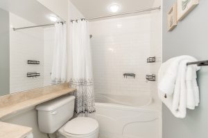 Clean and modern bathroom with bathtub and vanity.