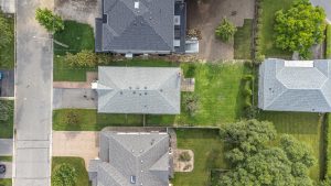 Aerial view of suburban houses with green lawns and streets.