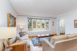 Bright and cozy living room with large windows and comfortable seating.