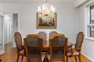 Elegant dining room with wooden chairs and chandelier.