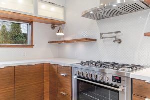 Modern kitchen with wooden cabinets and stainless steel stove.