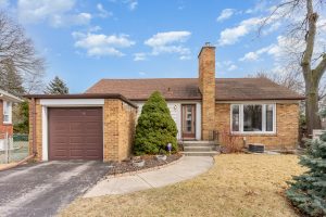 Cozy single-story brick house with an attached garage and a small front yard.